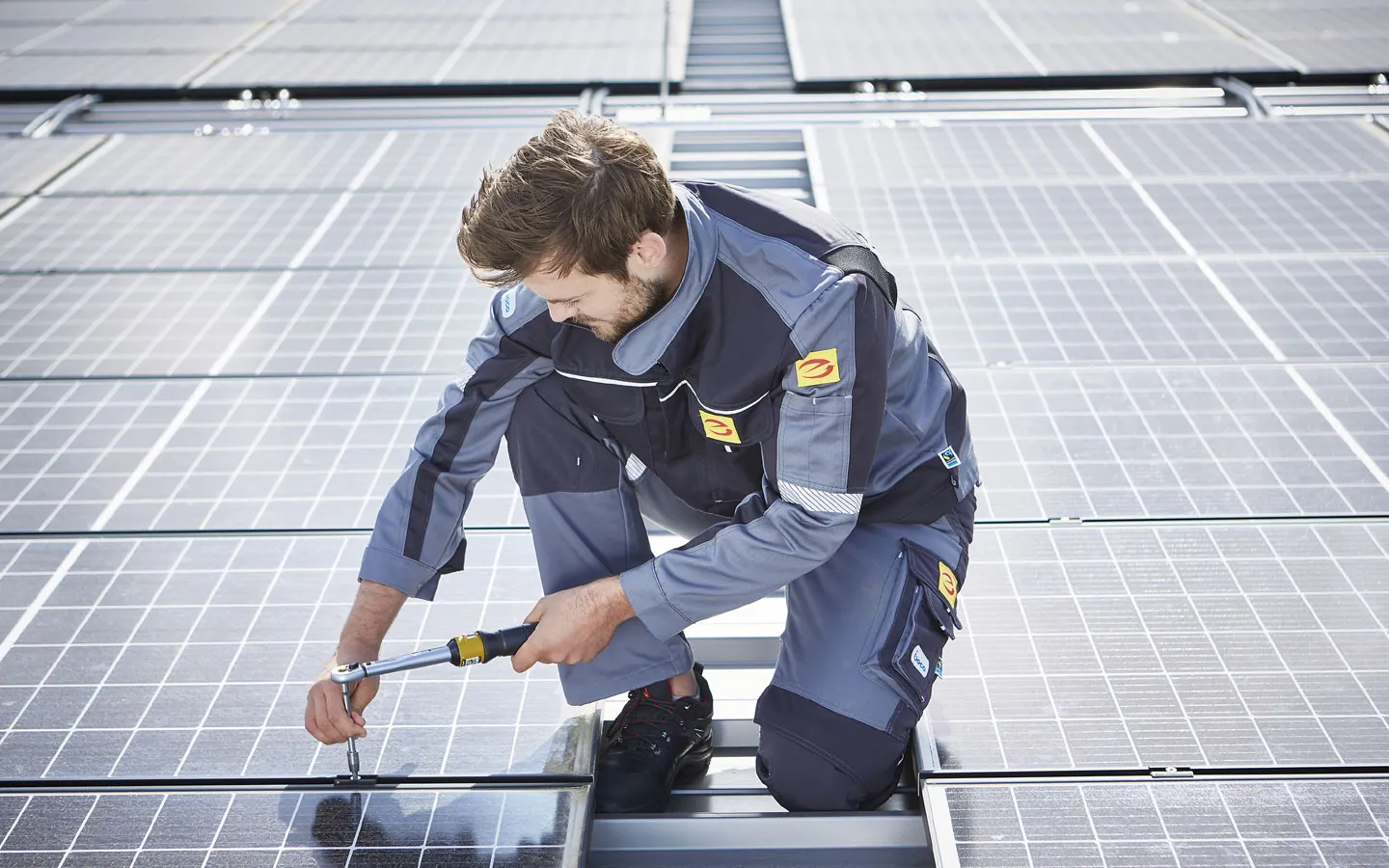 E-CHECK E-Mobilität - Mitarbeiter montiert auf dem Dach die neuen Solarmodule &middot; Elektro-Stock